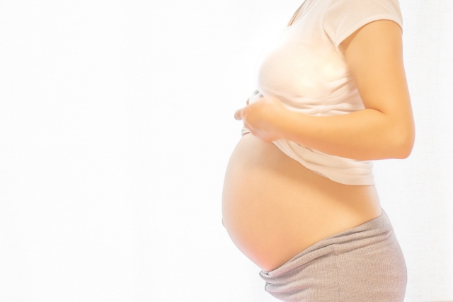 横向きでお腹を出している妊婦