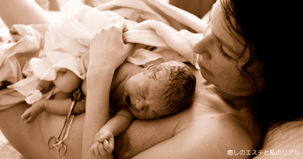 へその緒が付いたままの赤ちゃんをカンガルーケアで抱いているママ